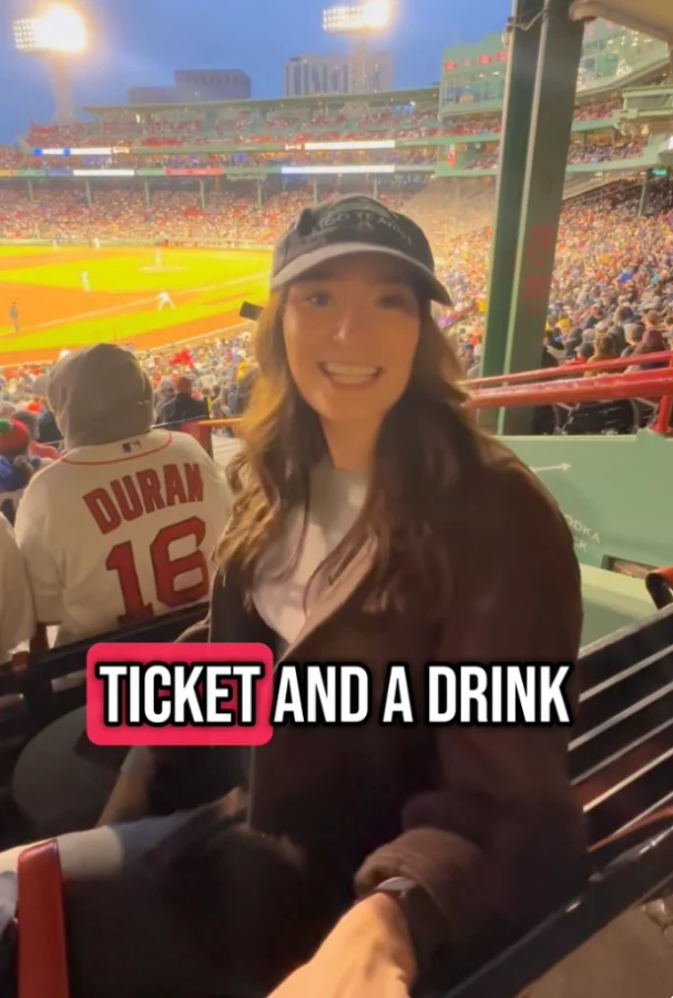 A fan at Fenway sharing a ticket and a drink
